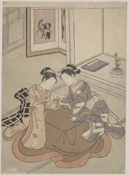 Zwei junge Frauen sitzen an einem Kotatsu und spielen Fadenspiel